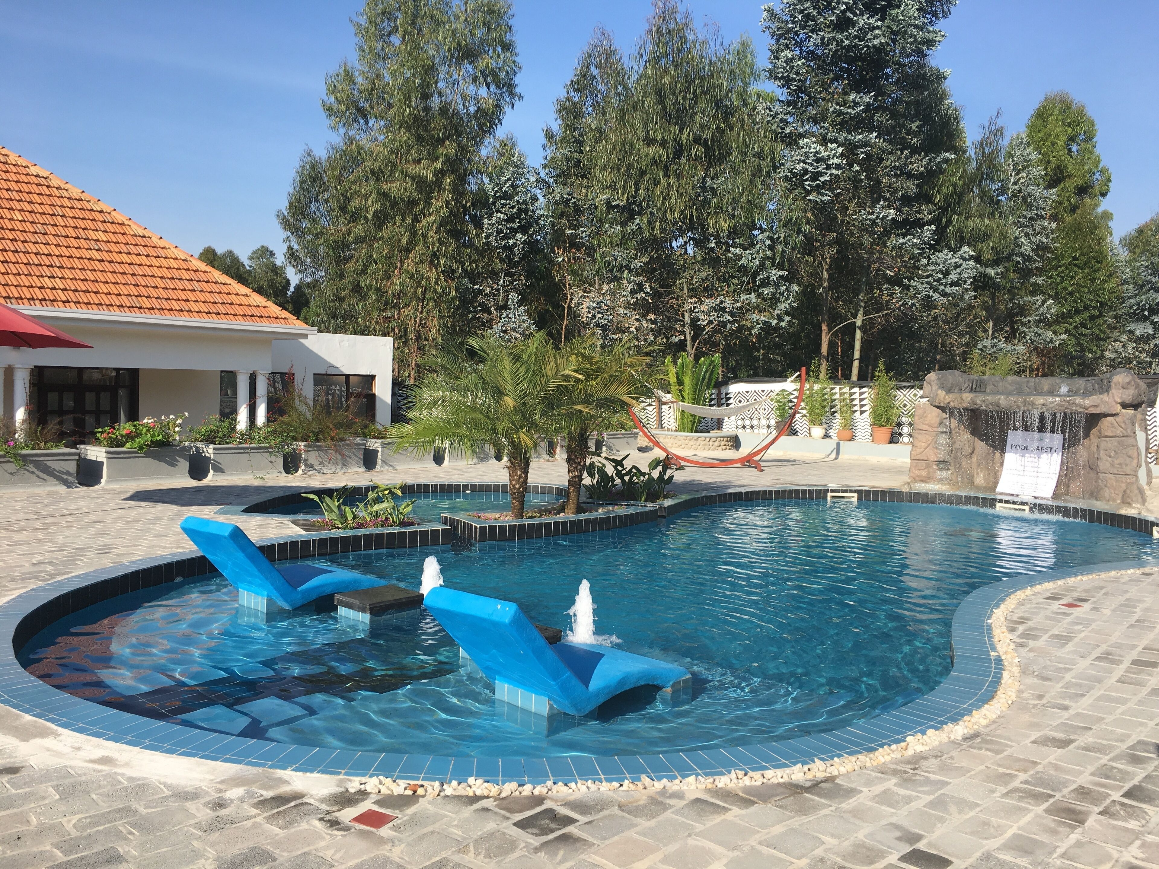 حمّام سباحة خارجي، مظلات على حمّام السباحة، مقاعد للتشمس