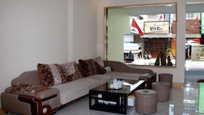 A modern living room with a sofa, ottomans, and a coffee table.