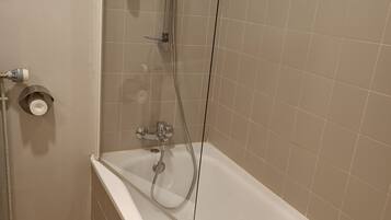 Une salle de bain moderne équipée d’une baignoire, d’une douche et de toilettes.