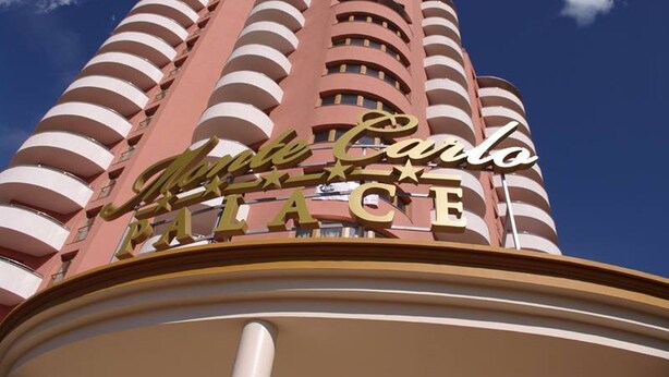 Un edificio alto con un letrero que dice "Monte Carlo Palace".