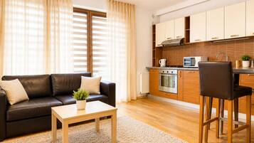 A modern living room with a sofa, coffee table, and a small potted plant.