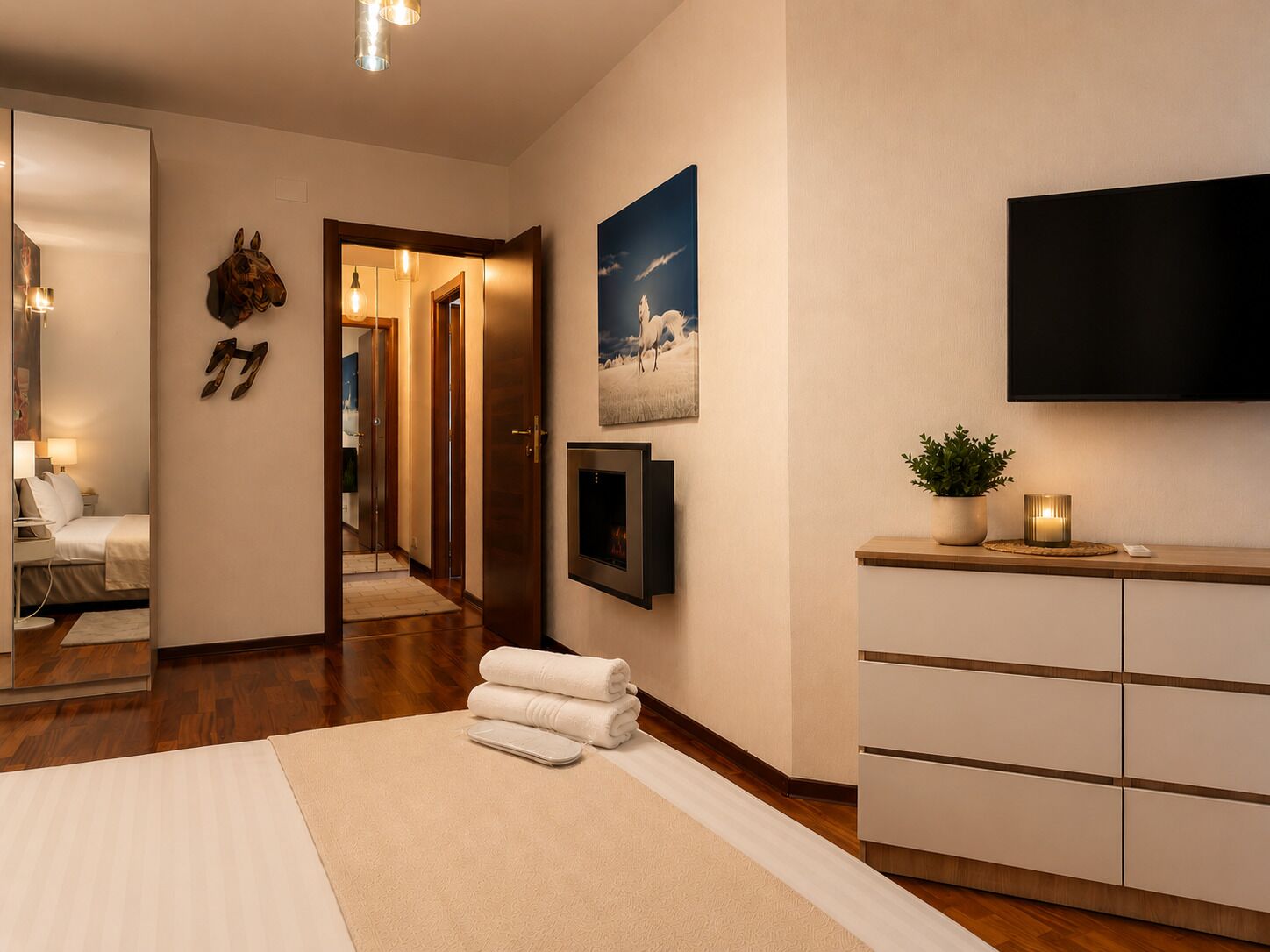 Una habitación de hotel con una cama, un televisor, una planta y un cuadro en la pared.