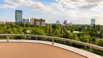 Un balcón con vista a un paisaje urbano, que incluye varios edificios y un río.