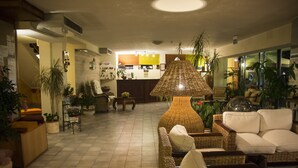 A spacious lobby with wicker furniture, a reception desk, and various potted plants. - Hotel Club Misano (Misano Adriatico)
