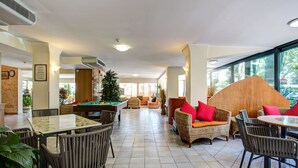 A spacious indoor area with a pool table, comfortable seating, and large windows offering natural light. - Hotel Club Misano (Misano Adriatico)