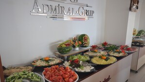 Mostrador de buffet con diversos alimentos y un cartel que dice 'Admiral Group'.