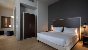 A modern bedroom with a large bed, a wardrobe, and a desk with a lamp. - Art Hotel Olympic (Turin)