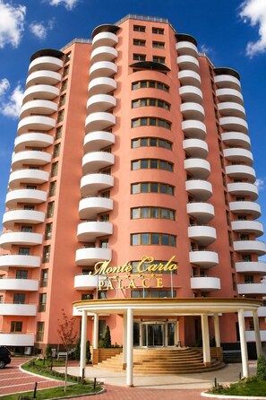 Un hotel de varios pisos con un letrero llamativo que dice 'Monte Carlo Palace'.