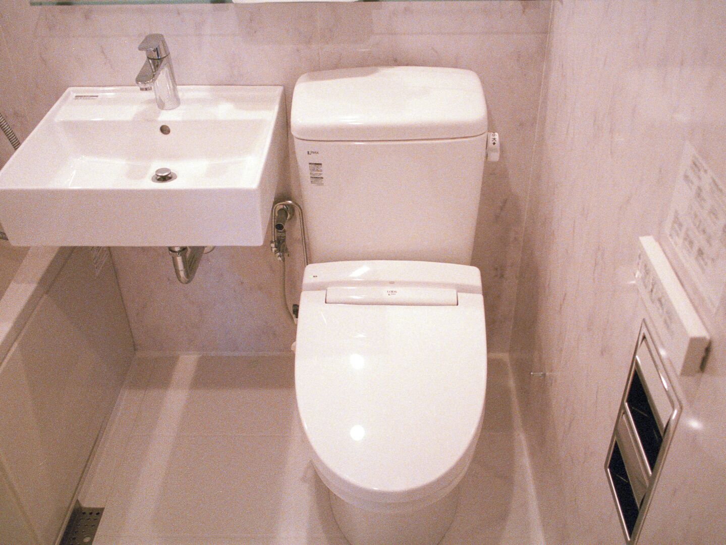 A bathroom with a white sink, toilet, and shower.