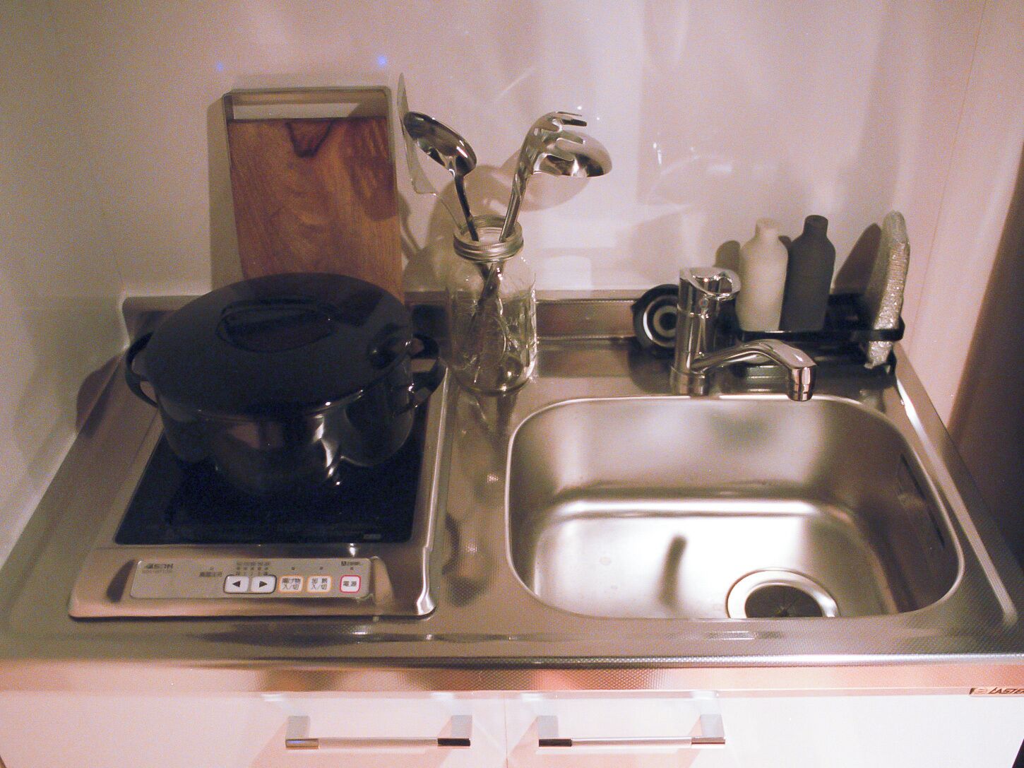 A kitchen with a built-in stove, a sink, and a microwave.