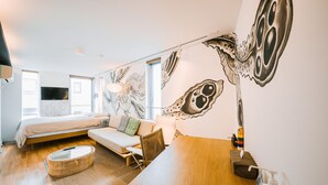 Une chambre moderne avec un lit, un canapé et une table à manger.