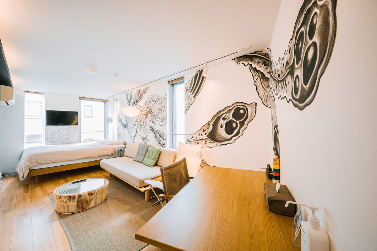 Une chambre moderne avec un lit, un canapé et une table à manger.