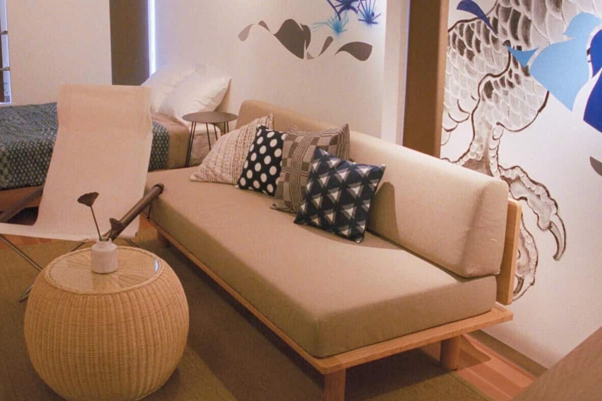 Une pièce chaleureuse avec un canapé, un fauteuil, une petite table et un mur décoratif.