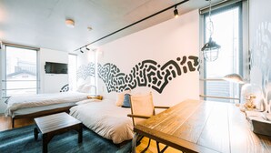 Une chambre moderne avec une grande table en bois, deux lits et un décor mural original.