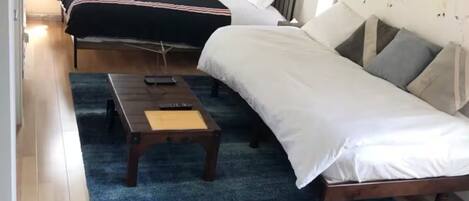 Habitación con dos camas, un televisor y una pared decorada con arte abstracto.