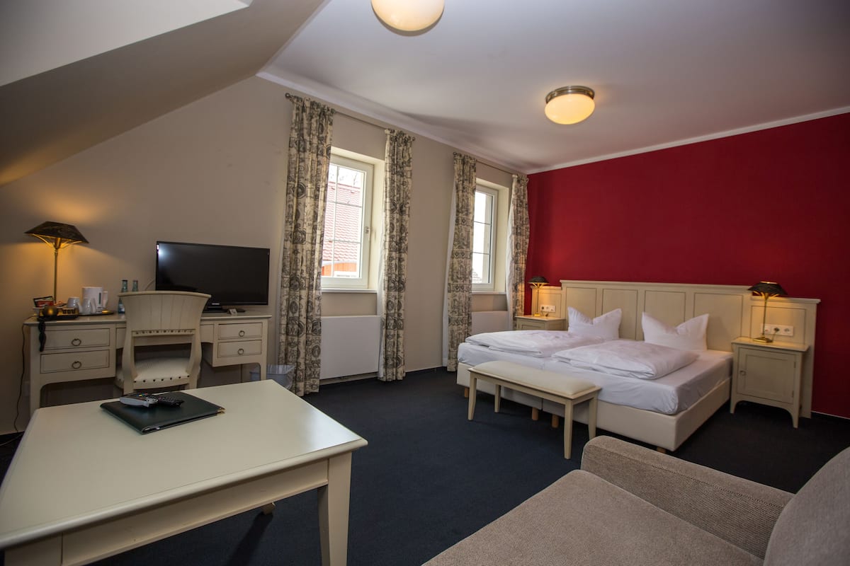Une chambre d’hôtel équipée d’un lit, d’un bureau, d’une chaise et d’un téléviseur.