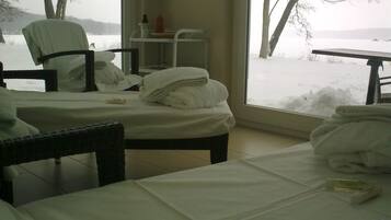 Enjoy breathtaking views of the snowy landscape from the comfort of this cozy room, featuring two plush beds and a peaceful seating area.