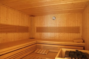 Una sauna de madera con bancos y un asiento de banco.