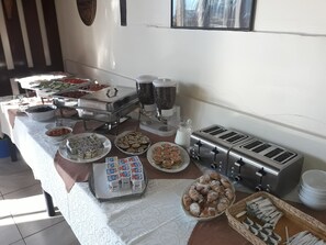 A buffet table with various food items, including fruits, pastries, and condiments. - Iri Busteni Hotel (Busteni)