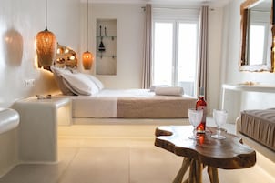 Una habitación de hotel con una cama, una mesita de noche y una mesa de madera con dos vasos.