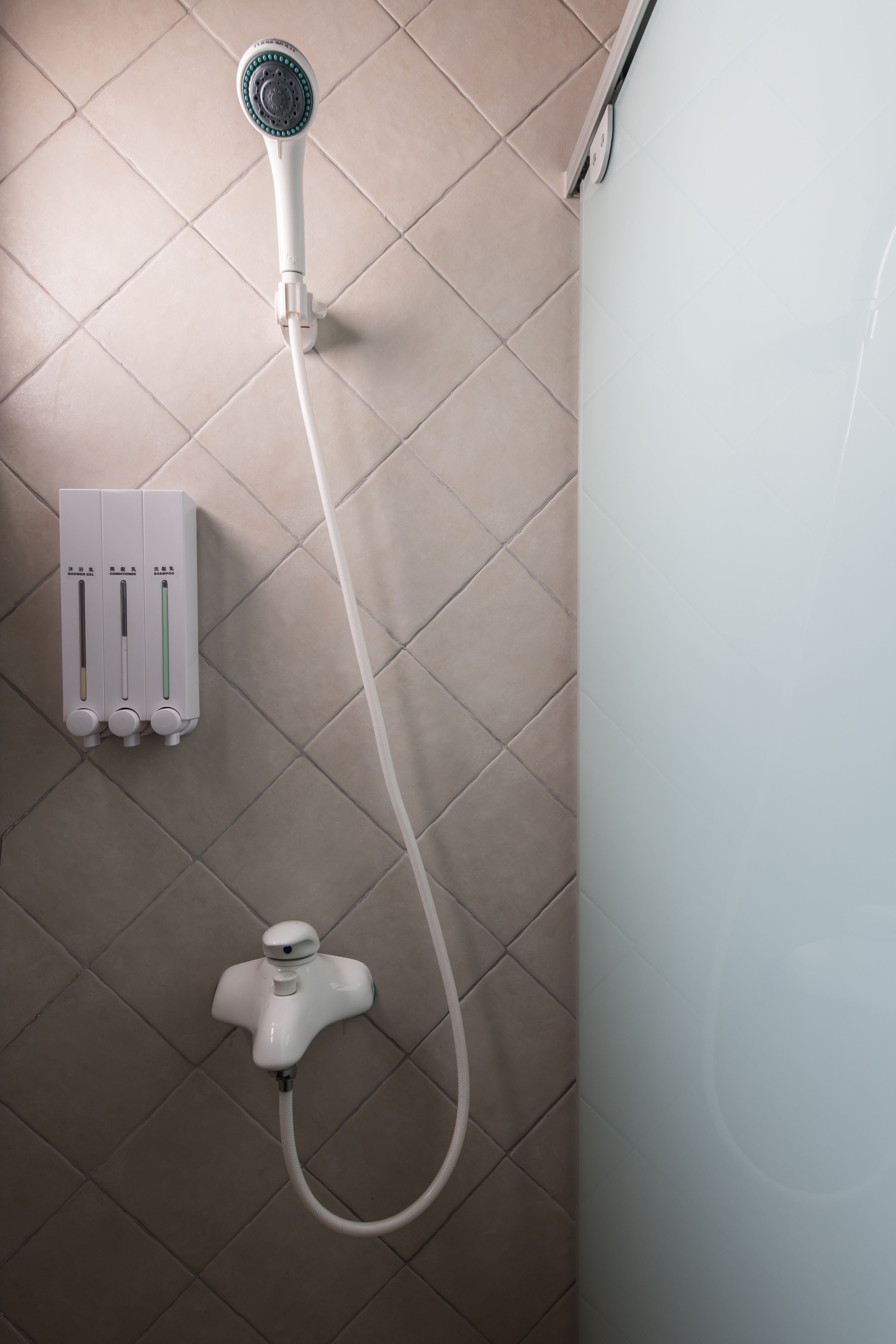 Een douche met een handdouche en een handbedienbare kraan.