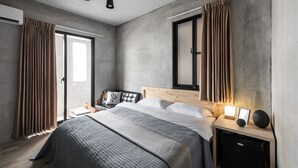 Un dormitorio moderno con una cama grande, mesitas de noche, un aparador y un armario empotrado.
