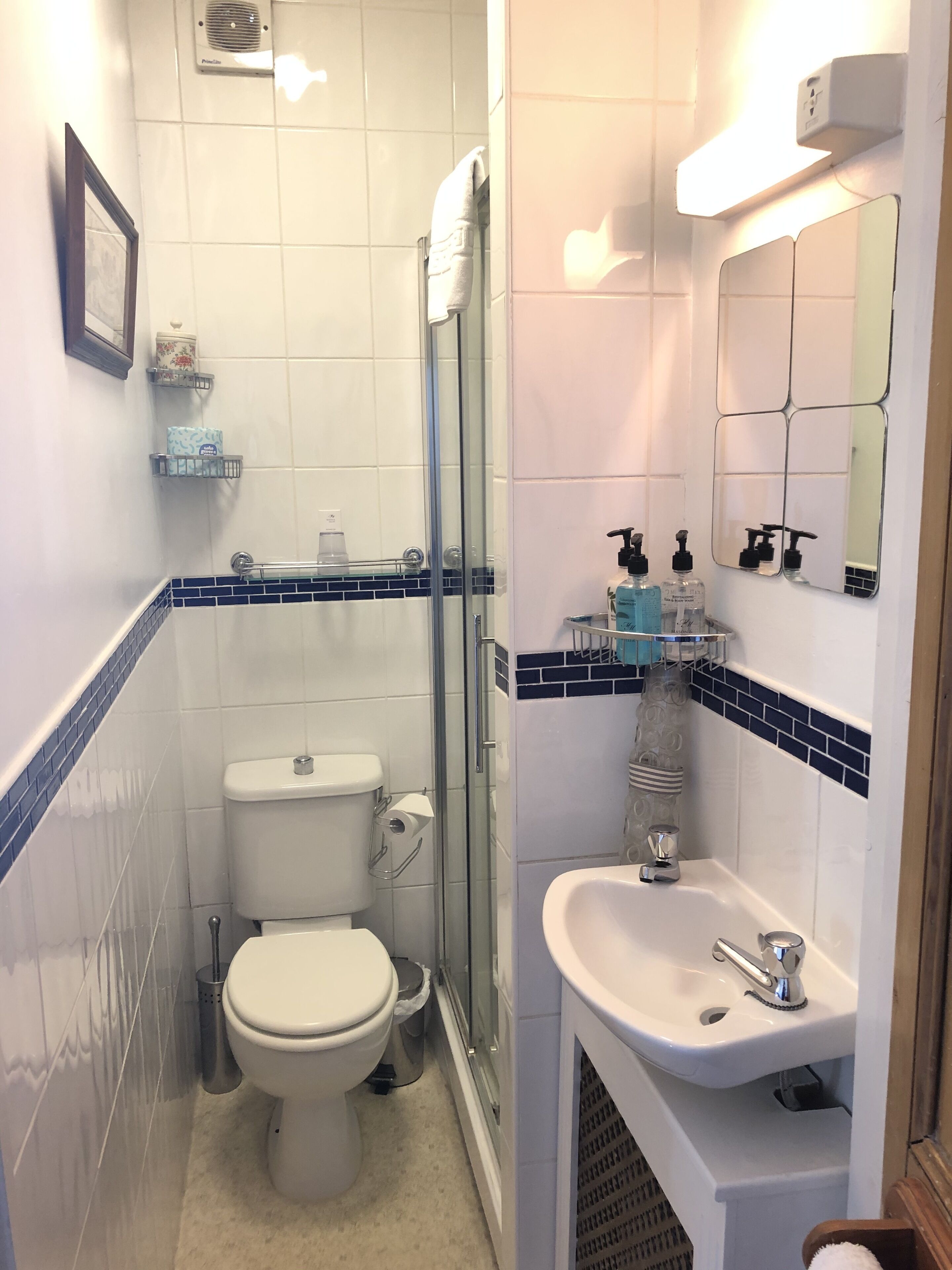 A bathroom with a toilet, shower, and sink.