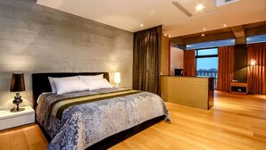 A modern bedroom with a large bed, a desk, and a view of the city. - Hiten B&B (Wujie)