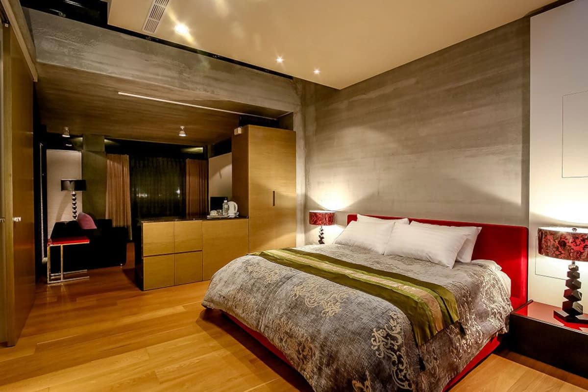 Une chambre moderne dotée d’un grand lit, d’un dressing et d’un coin salon séparé.