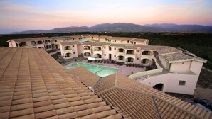 Un hôtel doté de nombreux balcons, d’une cour intérieure et offrant une vue sur les montagnes lointaines.