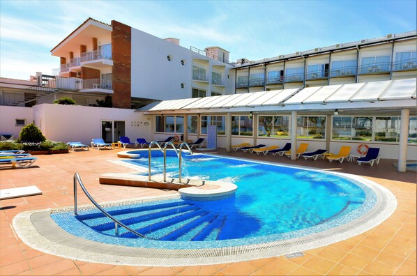 Alberca al aire libre y camastros 