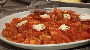 Un plato de tomates picados con queso y hierbas.