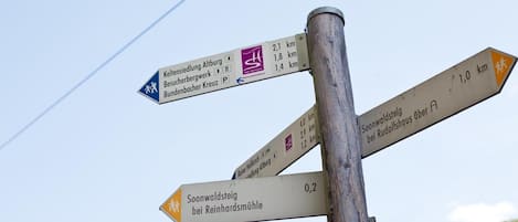 A directional signpost with multiple arrows pointing towards various destinations, each with distance markers.