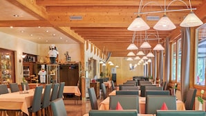 A restaurant with wooden ceilings and multiple dining tables with chairs. - Hotel Forellenhof (Bundenbach)