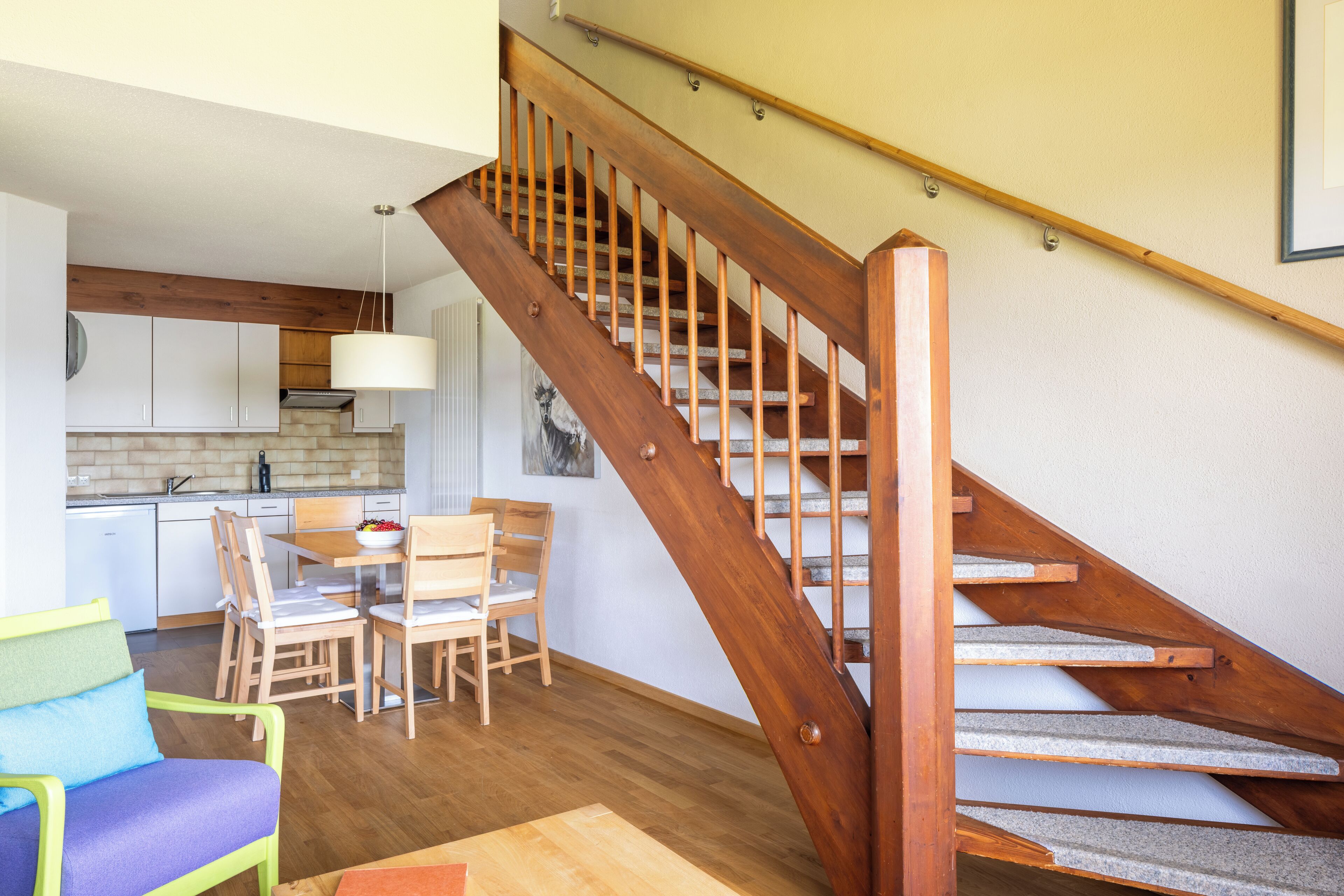 A staircase with wooden steps and a handrail, leading to an upper floor.
