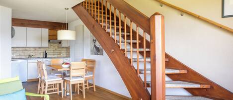 A staircase with wooden steps and a handrail, leading to an upper floor.