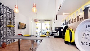 A modern kitchen with a dining table, yellow kettle, and a wall with cityscape silhouettes. - Golden Sun Apartments- Polanki (Kolobrzeg)