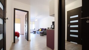 A modern living room with a sofa, coffee table, and a dining area. - Golden Sun Apartments- Polanki (Kolobrzeg)