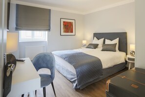A hotel room with a bed, bedside tables, a desk, a chair, and a window. - Hotel zur Schloss-Schmiede (Kühbach)