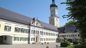 A historic building with a central courtyard, a tower with a dome, and a statue of a horse. - Hotel zur Schloss-Schmiede (Kühbach)