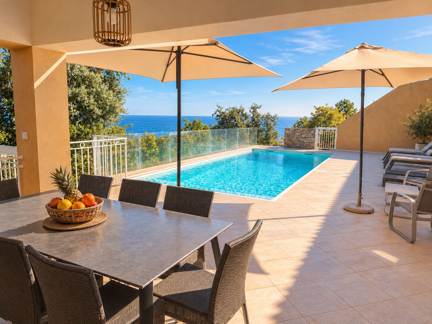 A poolside area with a table, chairs, and umbrellas.