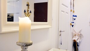 A bathroom with a white sink, a mirror, and a candle on a wooden vanity. - Golden Sun Apartments  - Bursztynowe (Kolobrzeg)