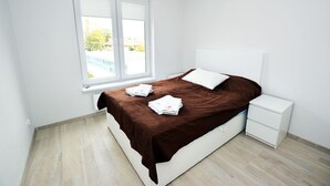 Um quarto com uma cama, uma mesa de cabeceira, uma janela e vista para o exterior.