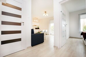 A modern interior with a kitchen area, a dining table, and a sofa.