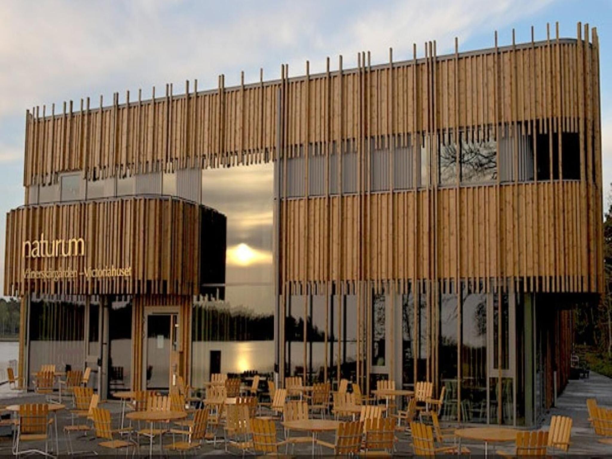 A modern building with a wooden facade and a sign that reads "naturum."