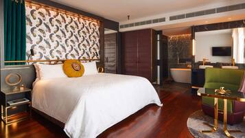 Una habitación de hotel moderna con una cama grande, una tocador con espejo y un televisor montado en la pared.