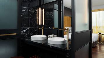 A modern bathroom with two round sinks, a large mirror, and a wooden bench.