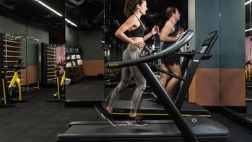 A gym with treadmills, weight machines, and mirrors.