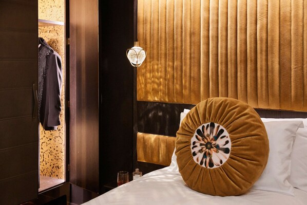 A hotel room with a bed, a nightstand, a lamp, and a wardrobe.