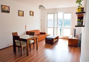 Relax in this stylish living room with a sofa, dining table, and flat-screen TV.
